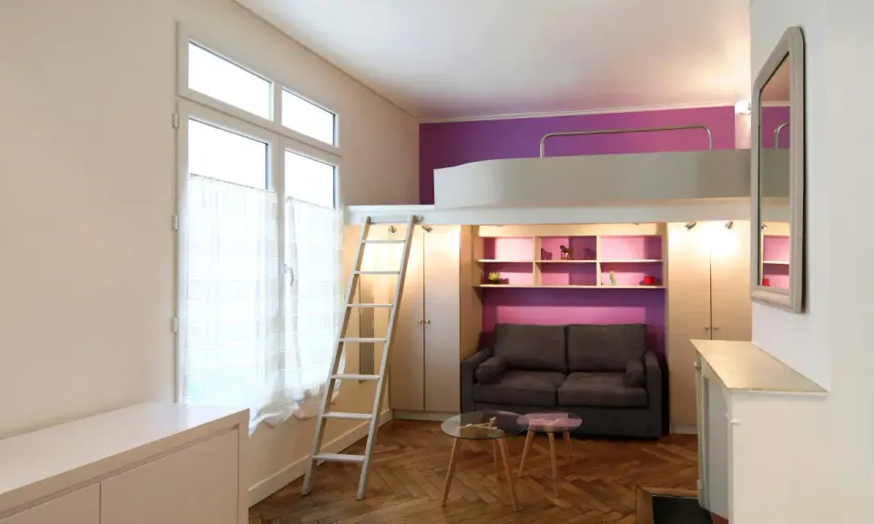 Un studio optimisé de plan 20m2 avec lit mezzanine, canapé, étagères violettes et échelle.