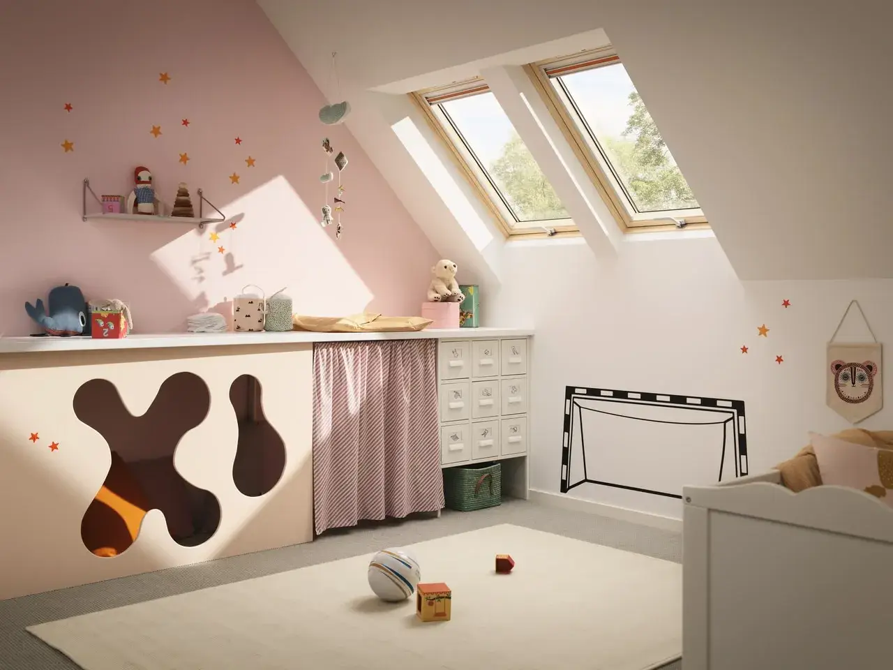 Idéale pour aménager petite chambre bébé sous combles : un espace ludique et douillet avec des jouets, des étoiles au mur et des fenêtres de toit.