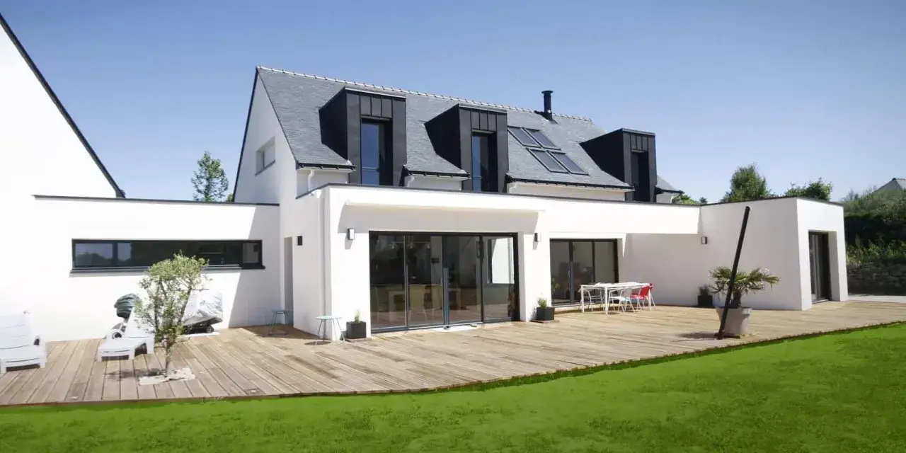 La maison Elian, moderne et lumineuse, avec sa terrasse en bois et son jardin verdoyant.