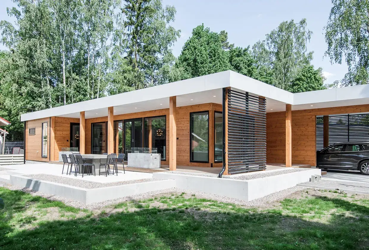 Une élégante maison bois moderne plain pied avec de grandes baies vitrées, une terrasse et un abri pour voiture.