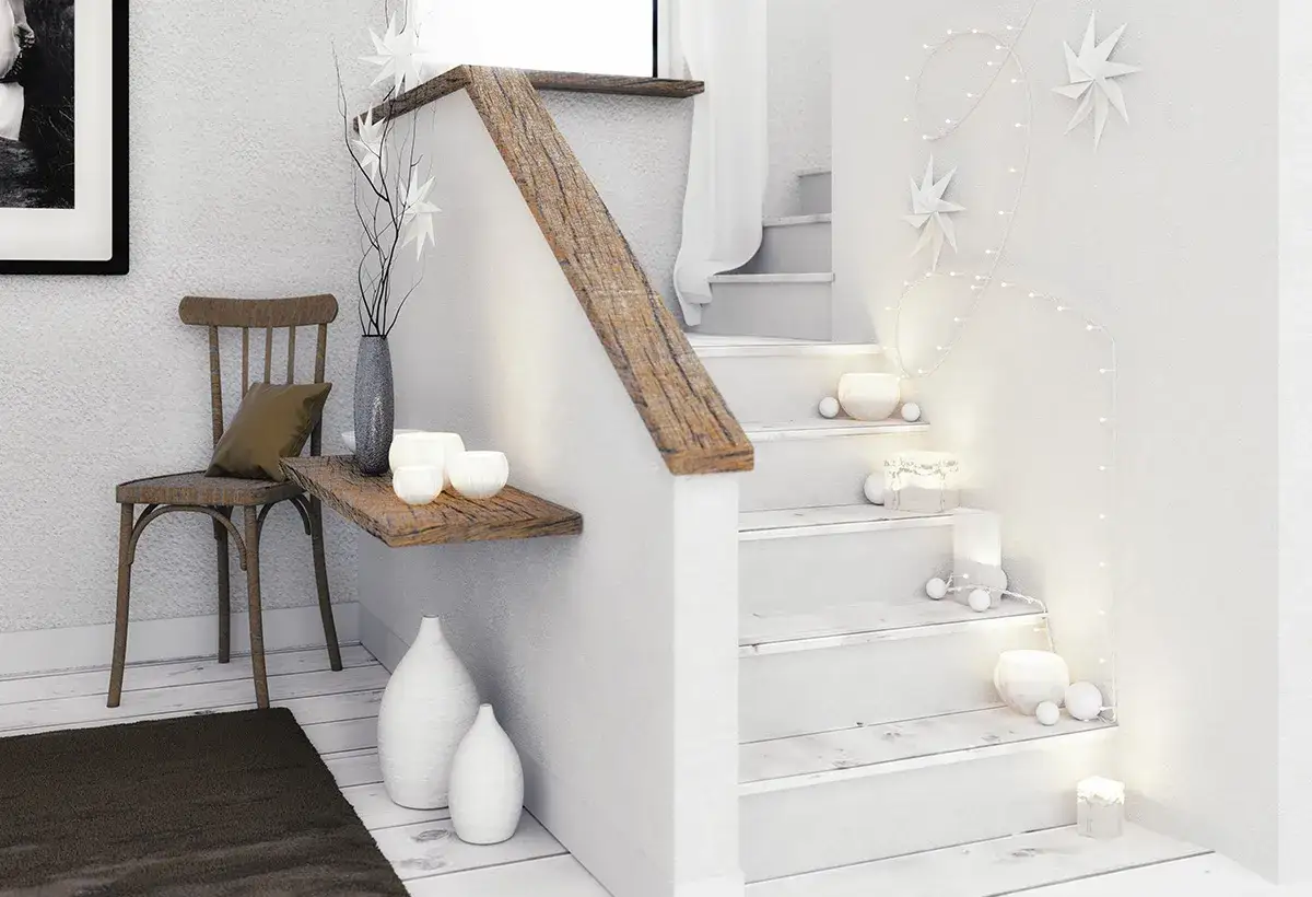 Un miroir dans une mont&eacute;e d'escalier, d&eacute;cor&eacute;e de guirlandes lumineuses et d'&eacute;toiles en papier, cr&eacute;e une ambiance chaleureuse et festive.