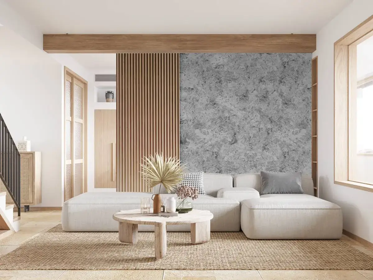 Un salon moderne avec un canapé blanc, une table basse en bois et un mur texturé gris pour habiller le fond.