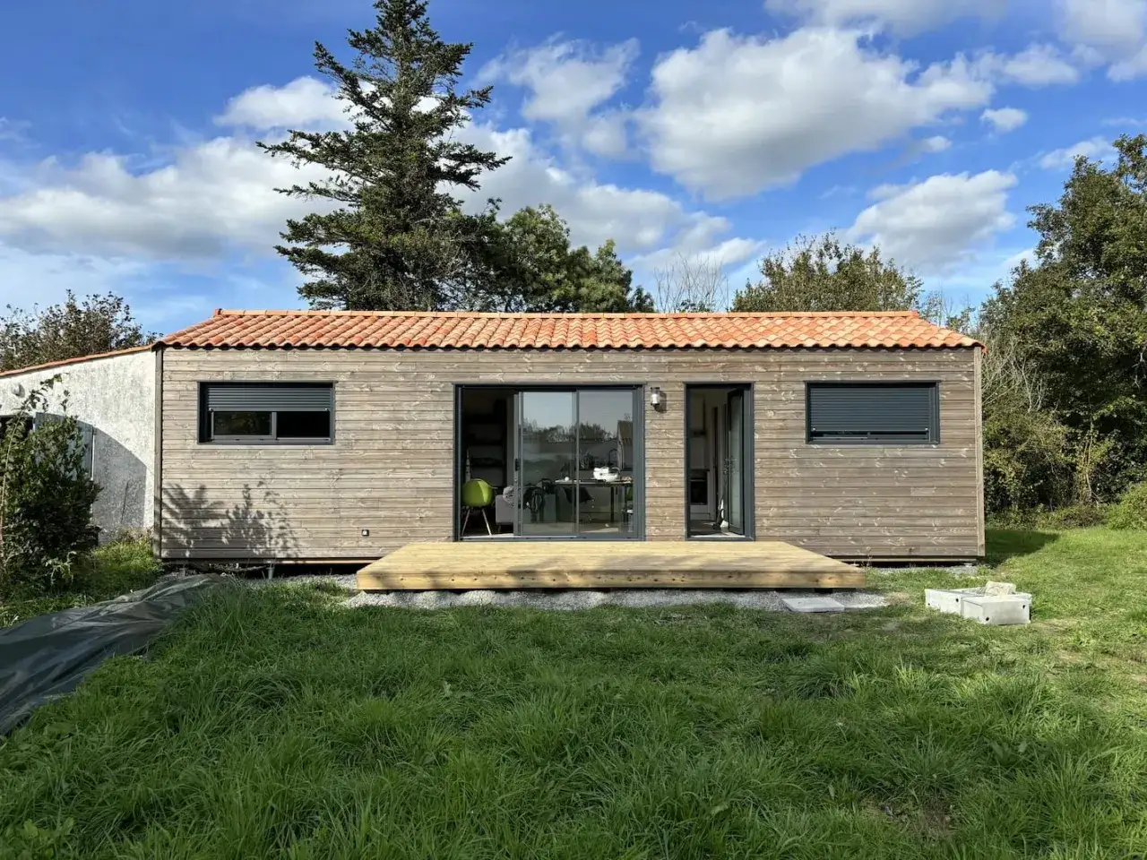 Maison Booa moderne en bois avec terrasse, toiture tuiles. Prix m2 attractif pour ce type de construction écologique.