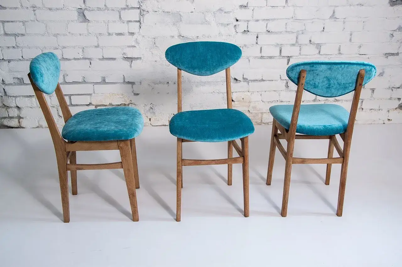 Trois vieilles chaises en bois relookées avec un tissu bleu turquoise. Une belle idée déco pour redonner vie à vos meubles.