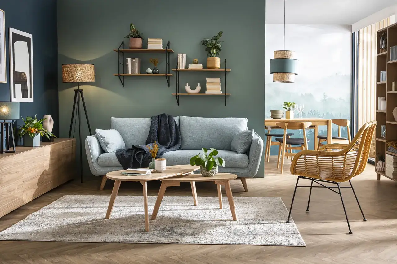 Un salon cosy avec un canapé bleu clair, des étagères murales et un cadre au dessus du canapé.