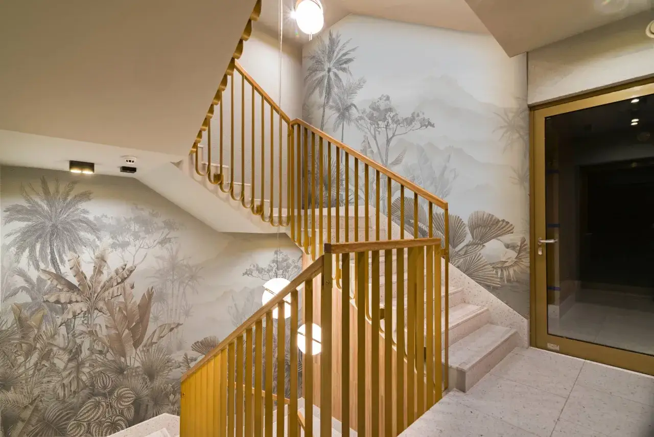 Habillage mur cage d'escalier avec une fresque tropicale. Escalier en bois et pierre, porte vitrée.