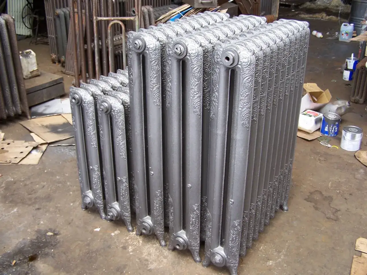Une rang&eacute;e de radiateurs en fonte argent&eacute;s, pr&ecirc;ts &agrave; &ecirc;tre install&eacute;s. Ces pi&egrave;ces classiques permettent de reconna&icirc;tre radiateur haute temp&eacute;rature et apportent une touche d'&eacute;l&eacute;gance.