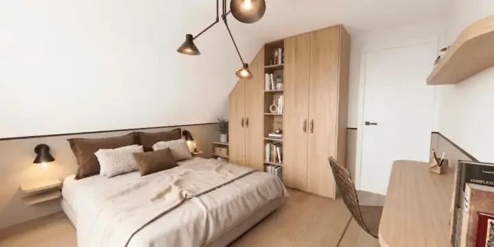 Chambre mansardée cosy avec lit douillet, armoire en bois et étagères remplies de livres. Un bureau et une chaise complètent l'espace.
