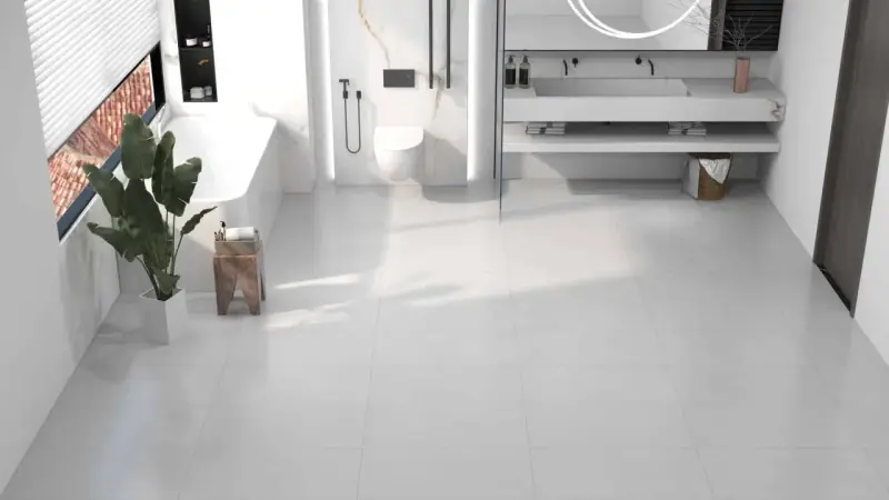 Salle de bain moderne avec baignoire, douche, lavabo et toilettes, le tout sur un sol en dalle pvc ou carrelage blanc.